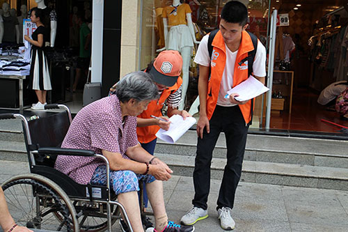 兩名隊員在向奶奶口述問卷問題 （李曉妍 攝）