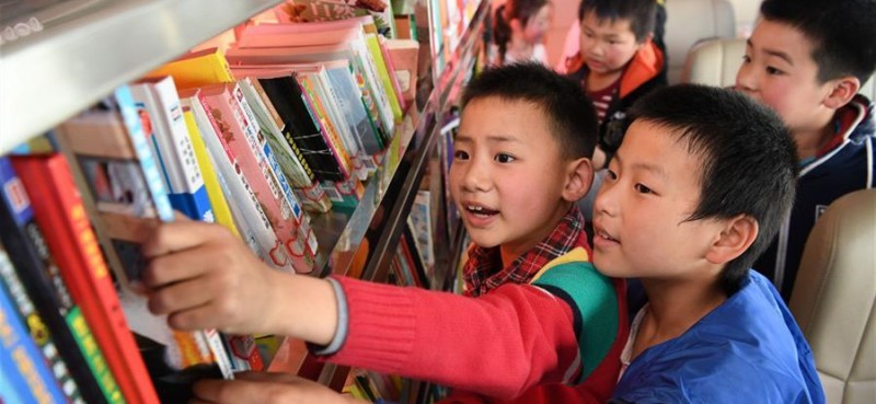        4月17日，岳西縣冶溪鎮白沙小學學生在“汽車圖書館”上挑選圖書。當日，安徽向日葵公益助學服務中心聯合合肥市少年兒童圖書館開展“流動的書香——一本圖書的愛心之旅”活動，為安徽省岳西縣冶溪鎮白沙小學的學生們捐贈600多冊圖書，并設立“汽車圖書館”，為山區學生提供閱讀便利。