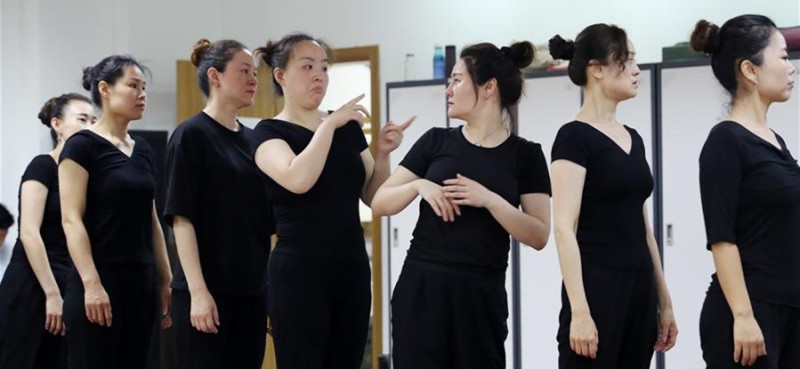 5月26日，兩名舞蹈隊員在聊天。 在上海閔行區古美路街道，有一個由聽力障礙者組成的舞蹈團隊——古美彩韻聾人舞蹈藝術隊。舞蹈隊現有20名隊員，年齡從20歲到40歲，由上海戲劇學院舞蹈學院的老師每周一次為隊員們提供訓練指導。對舞蹈藝術的熱愛，讓這些聽力障礙者走到了一起，在無聲世界里舞出精彩人生。
