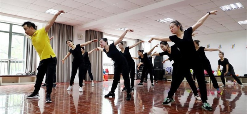 5月26日，上海戲劇學院舞蹈學院劉建強老師（左）帶領隊員們排練舞蹈。 在上海閔行區古美路街道，有一個由聽力障礙者組成的舞蹈團隊——古美彩韻聾人舞蹈藝術隊。舞蹈隊現有20名隊員，年齡從20歲到40歲，由上海戲劇學院舞蹈學院的老師每周一次為隊員們提供訓練指導。對舞蹈藝術的熱愛，讓這些聽力障礙者走到了一起，在無聲世界里舞出精彩人生。