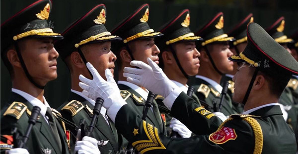 教官正在為一名訓練中的儀仗方隊陸軍戰士糾正軍姿。身姿要挺拔威嚴，步伐要整齊有力，口號要嘹亮高亢——為了在天安門前彰顯國威軍威，參閱官兵要經過成千上萬次的練習。