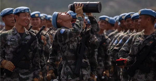 一名維和部隊方隊的戰士正在補水降溫，他們訓練中每天需要補充1升多的水。