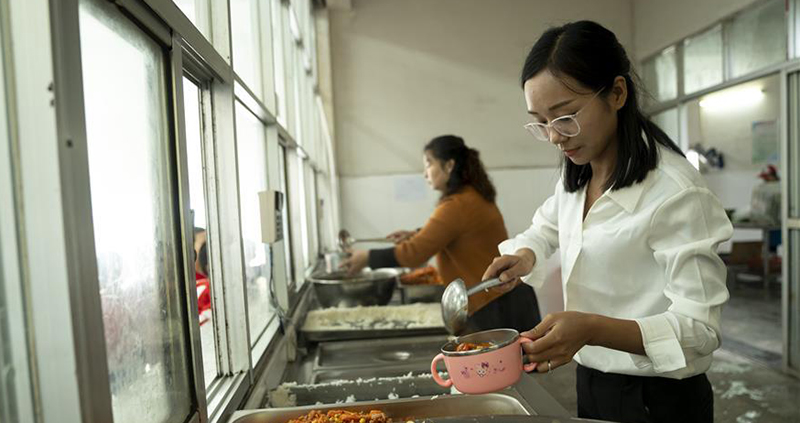 方榮在羅田縣希望小學食堂給學生打飯。