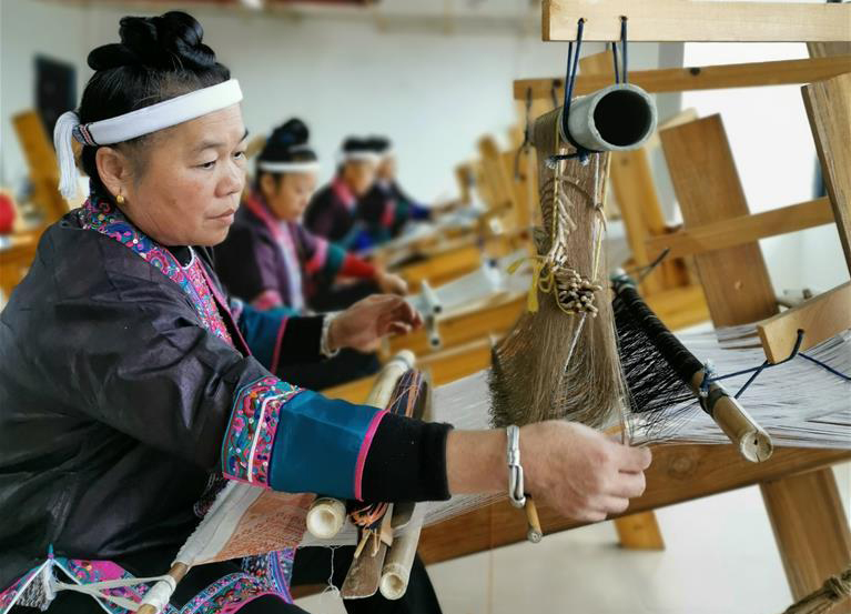 　11月27日，在廣西柳州市三江侗族自治縣古宜鎮南站社區易地扶貧搬遷安置小區，侗族婦女在扶貧就業工坊里織造侗錦。

　　侗族刺繡和織錦是獨具民族特色的傳統手工技藝，具有悠久的歷史。近年來，廣西柳州市三江侗族自治縣積極引導當地侗寨婦女發展侗族刺繡、織錦等“指尖經濟”，多渠道拓寬非遺產品銷路，讓侗族婦女在家門口就業創業，實現顧家、傳藝、脫貧“三不誤”，巧織侗鄉“錦繡脫貧路”。目前全縣共有5000余人從事“錦繡”扶貧產業。