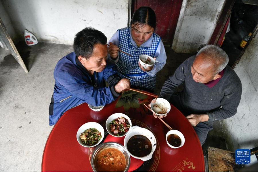 　趙友良（左）吃午飯時(shí)給父親夾菜（5月12日攝）。

　　趙友良和簡(jiǎn)琴是生活在貴州省遵義市正安縣中觀鎮(zhèn)大山深處的一對(duì)殘疾人夫妻。50歲的趙友良幼年因燙傷截肢失去雙手，43歲的簡(jiǎn)琴因兒時(shí)患病拖延治療雙目失明。

　　平日里，趙友良的眼也是妻子的眼，簡(jiǎn)琴的手也是丈夫的手，夫妻兩人相互攙扶、相濡以沫。趙友良做事麻利，在地里勞作時(shí)是一把好手，在家會(huì)幫助妻子打理家務(wù)；簡(jiǎn)琴為人勤快，除了洗衣做飯，也和丈夫一起下地干活。

　　從1999年結(jié)婚至今，趙友良和簡(jiǎn)琴克服重重困難，一路相伴前行。發(fā)展產(chǎn)業(yè)、修建新房、贍養(yǎng)老人、供兒女上學(xué)……他們依靠自己的勤勞擺脫了貧困，并在各級(jí)部門(mén)的幫助下，生活變得越來(lái)越美好。

　　新華社記者 楊文斌 攝